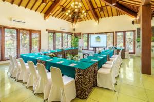 库塔瑞萨塔巴厘岛假日及温泉酒店的一间会议室,配有长桌和白色椅子