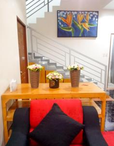 GuinobatanMajestique Hotel Albay Bicol的一张木桌,上面有两朵盆花