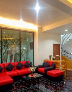 GuinobatanMajestique Hotel Albay Bicol的客厅配有红色的沙发和桌子