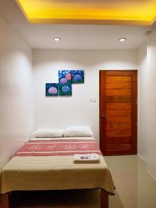 GuinobatanMajestique Hotel Albay Bicol的一间卧室配有一张床和一扇木门