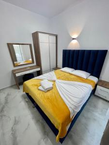 乌尔齐尼Lindi apartments的一间卧室配有一张大床和蓝色床头板
