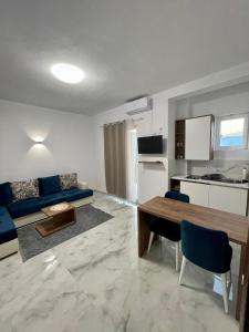 乌尔齐尼Lindi apartments的客厅配有蓝色的沙发和桌子