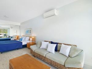 耐莉湾蓝上蓝1322度假屋的客厅配有沙发和1张床