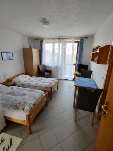 克拉托维Pension Nela的客房设有两张床、一张桌子和一个窗户。