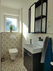 WeierMuhrbach的一间带卫生间、水槽和窗户的浴室