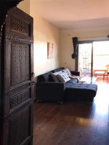 马拉喀什Safran flat with 2 large terraces Central Location的带沙发和大型木门的客厅