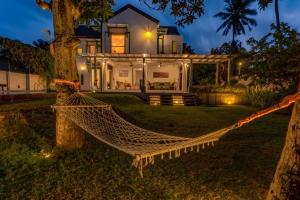 尼甘布Astig Villa - Negombo的夜间房子前面的吊床