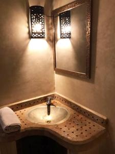 马拉喀什Safran flat with 2 large terraces Central Location的浴室水槽设有两盏灯和镜子