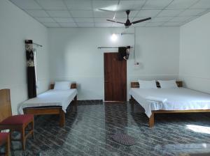 Jyoti GaonFalcon Jungle Resort的客房设有两张床和吊扇。