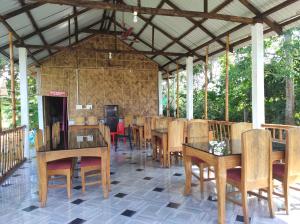 Jyoti GaonFalcon Jungle Resort的用餐室配有木桌和椅子