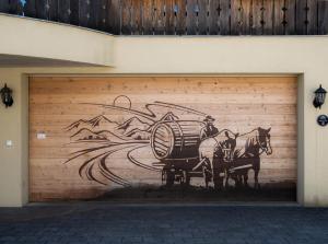 莫尔斯Doodle's Amazing Chalet -Walensee - Flumserberg - Churfirsten - Heidiland - Pool - Sauna的车库门,上面有一幅画,上面画着一个骑马的人