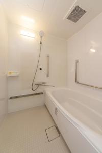 久留米市Suikouen Hotel的白色的浴室设有浴缸和淋浴。