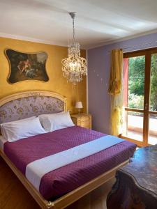 兰佐丁泰尔维Villa Marzia的一间卧室配有一张带吊灯的紫色床