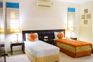 阿格拉Bansi Home Stay的酒店客房设有两张床和两盏灯。