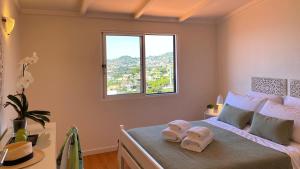 丰沙尔Casa ideal para famílias com vista mar desafogada的一间卧室配有一张床,上面有两条毛巾