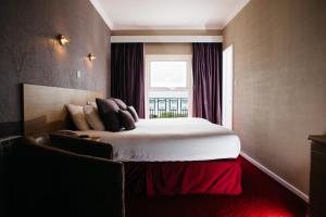 圣赫利尔泽西德诺曼蝶酒店的一间卧室设有一张大床和一个窗户。