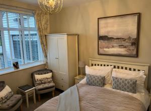 塞米斯湾Castellor Bed & Breakfast的一间卧室配有一张床、一把椅子和一个吊灯。
