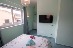 费拉约港Appartamento Sogno Marino的客房设有带窗户的床和电视。