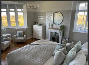 塞米斯湾Castellor Bed & Breakfast的一间卧室配有一张床、镜子和椅子