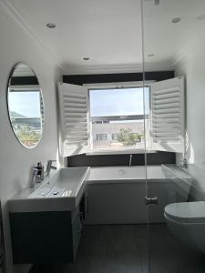 开普敦The Atlantic DonReal Guesthouse的一间带水槽和卫生间的浴室以及窗户。