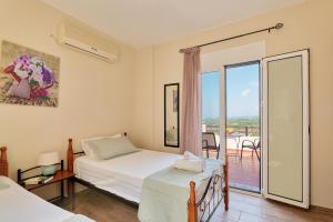 圣特里亚斯Exclusive Villa - Amazing View & Private Pool的一间带两张床的卧室和一个阳台。