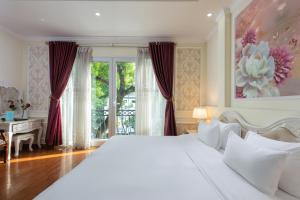 河内河内吾月酒店的卧室配有一张白色大床和一张书桌