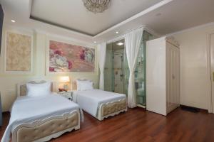 河内河内吾月酒店的一间卧室设有两张床和淋浴。
