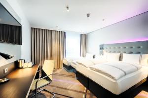 达姆施塔特Premier Inn Darmstadt City Centre的酒店客房设有三张床和一张书桌