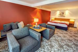 玛丽亚阿尔姆AlpenParks Hotel Maria Alm的酒店客房设有一张沙发和一张床