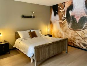 赫鲁斯贝克Camping Lagewald Vakantiehuis的卧室配有一张床,并画着一幅牛的照片
