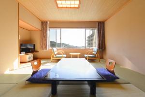 日光Ooedo Onsen Monogatari Hotel Kinugawa Gyoen的客房设有桌椅和大窗户。