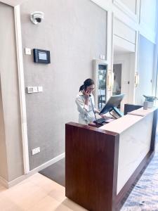 艾阿卡Address Beach Resort Fujairah Apartment 2 Bed Rooms and Small Bed Room - Ground Floor 3011的办公室里的一个女人在说手机