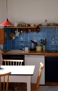 德意志兰茨贝格Apartment bei der Tischlerei的厨房拥有蓝色的瓷砖墙壁和厨房桌