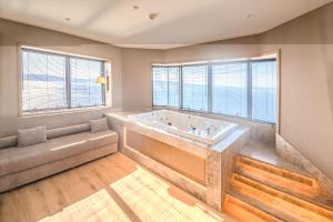 恰纳卡莱Kolin Hotel Spa & Convention Center的大型浴室设有大浴缸和窗户。