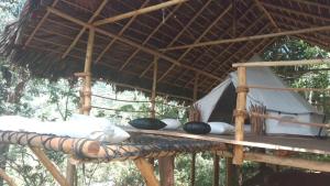 埃拉Ella Retreat Glamping Bell Tent For Nature Lovers的一张带草屋顶的木桌