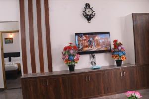 蒂鲁帕蒂Leo Home Stay的木制橱柜顶部的平面电视