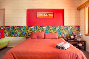 SilvanTreetops Silvan Valley Lodge - Suite 2的一间卧室配有一张带红色毯子的大床