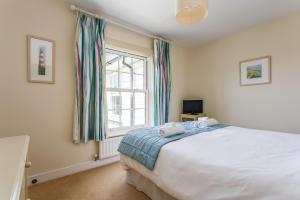 坎伯利Sands End的一间卧室设有一张大床和一个窗户。
