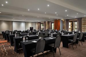 克拉伦斯克拉伦斯万豪Protea酒店的一间会议室,配有黑色的桌椅和屏幕