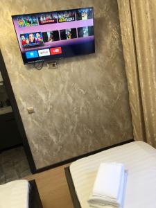 阿拉木图Hotel LION Almaty的一间设有床铺和墙上电视的房间