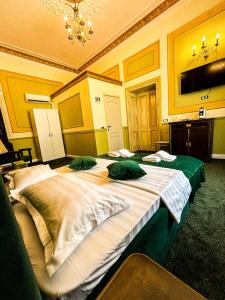 布加勒斯特Hotel Boutique Casa Vermont的一间卧室配有两张带绿色枕头的床。