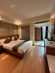 新德里The Orion Plaza - Nehru Place的一间卧室设有一张大床,铺有木地板