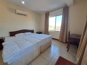 莫希Moshi Leopard Hotel的一间卧室设有一张大床和一个窗户。