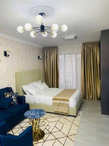 内罗毕Stunning Studio apartment in Kileleshwa的一间卧室配有一张床和一张蓝色的沙发