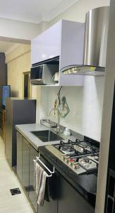 内罗毕Stunning Studio apartment in Kileleshwa的厨房配有水槽和炉灶 顶部烤箱