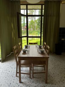 谢赫维蒂利Buxus Villas Shekvetili的餐桌、椅子和大窗户