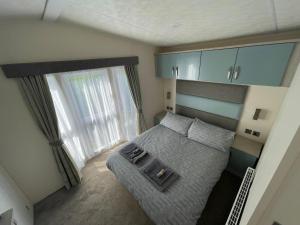 PlumblandLake District Luxury Lodge的一间小卧室,配有床和窗户