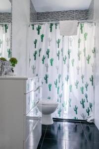 卡斯特尔德费尔斯Playa 4 a solo 3 min - Apartamento en Castelldefels的浴室设有卫生间和带仙人掌的浴帘。