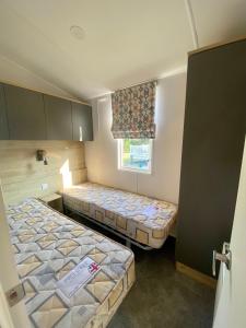 ChwilogHafan Y Môr Caravan - Pwllheli的小型客房 - 带2张床和窗户