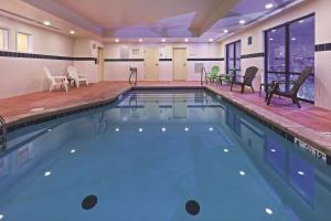 爱德蒙埃特德蒙拉昆塔套房酒店的大楼内带桌椅的大型游泳池